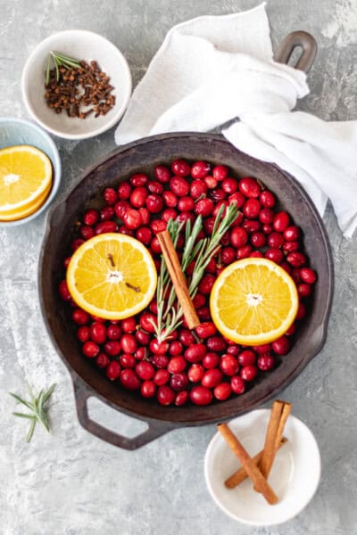 Cranberry Holiday Simmering Pot filled with fresh cranberries, orange slices, fresh rosemary, and a cinnamon stick.