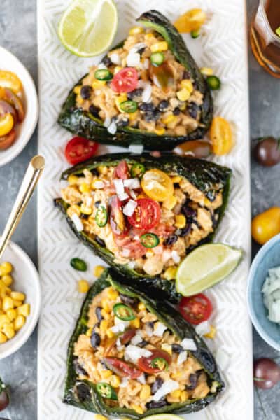 Stuffed Roasted Poblano Peppers with a creamy dairy-free sauce on a long rectangular plate