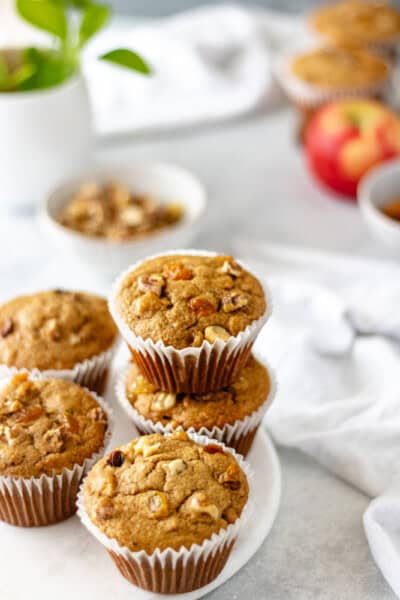 Chai-Sweet Potato Breakfast Muffins on a marble trivet surrounded by a bowl of nuts, raisins, and apple.