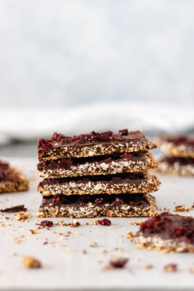 Stacks of Chocolate Cherry Quinoa Bars sitting on parchment paper.