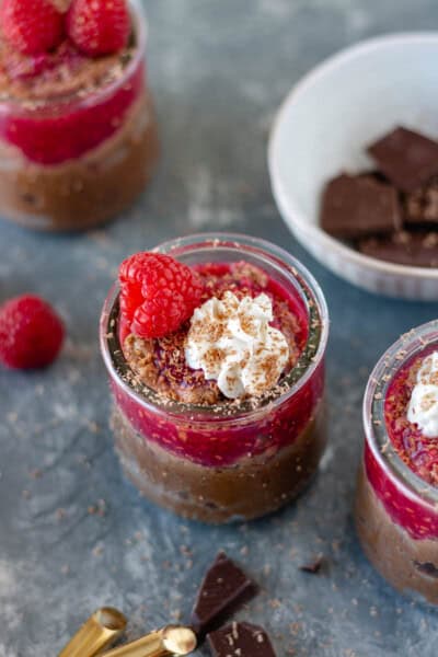 Three mini glass cups filled with a vegan chocolate raspberry mousse.
