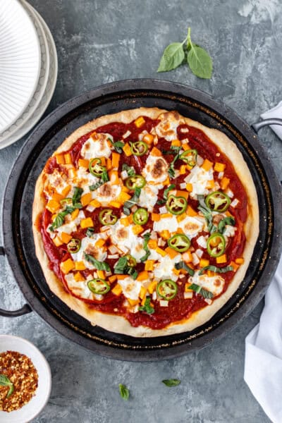 A supreme pizza on a baking stone.
