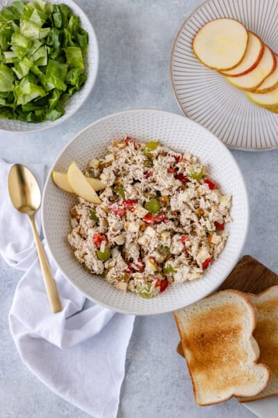 Shredded chicken, diced apple, bell pepper, onion, grapes and raisins mixed with mayo in a large serving bowl.